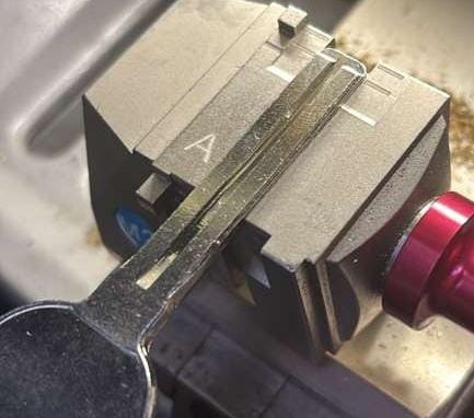 Key cutting machine cutting a new car key
